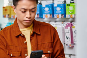 man looking at phone point of sale system